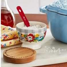 a bowl with rice in it next to a wooden spoon on a cutting board and other kitchen items