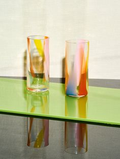 two glasses sitting on top of a green table