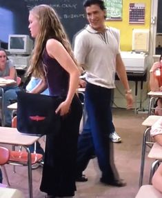 a man standing next to a woman in a classroom