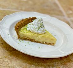 a piece of pie on a white plate with whipped cream and green sprinkles