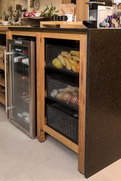 an open refrigerator sitting inside of a kitchen next to a counter with food in it