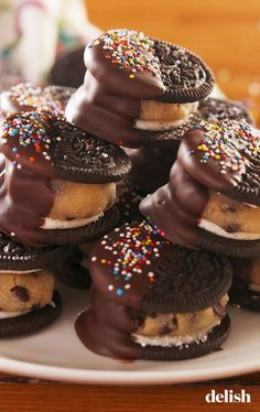 chocolate covered cookies with sprinkles and oreos arranged on a white plate