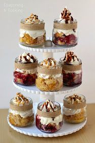 there are many desserts in glass jars on the cake stand