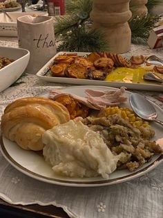 a white plate topped with lots of food on top of a table next to other dishes