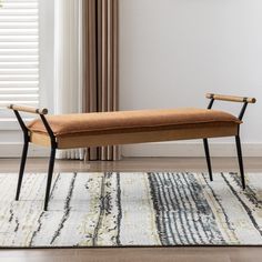 a bench sitting on top of a rug next to a window