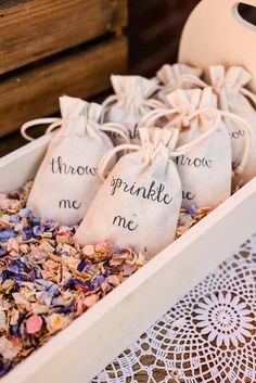 three bags filled with flowers sitting on top of a lace doily next to a vase