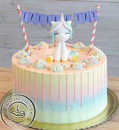 a birthday cake decorated with an unicorn on top