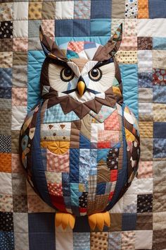 an owl is sitting on top of a quilt