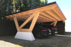 two cars are parked under a wooden structure