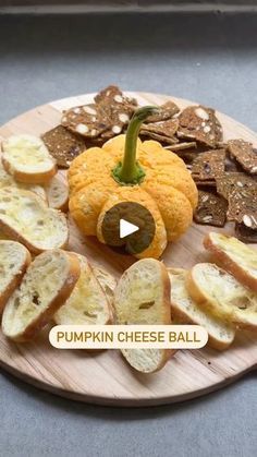 pumpkin cheese ball on a wooden plate with crackers