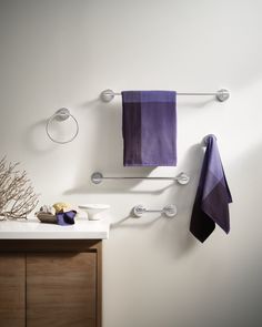 two towels hanging on the wall next to a sink