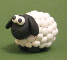 a black and white sheep made out of marshmallows on a green surface