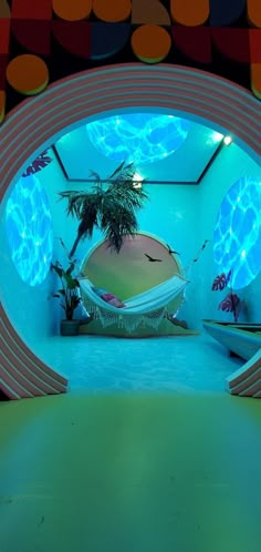 a room that has a hammock and palm tree in it with lights on the ceiling