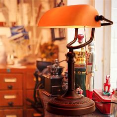 a lamp sitting on top of a wooden table next to a dresser with bottles and other items