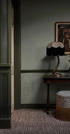 a leopard print footstool sitting next to a table with a lamp on it