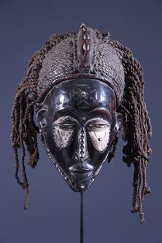 an african mask with dreadlocks on it's head