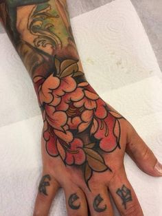 a tattooed hand with flowers on it