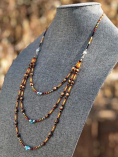 "Authentic Native American, handmade, tiered Cedar Juniper Berry seed with turquoise necklace. Cedar beads, colorful glass seed beads (size 11/0), round silver beads (6mm) and a gemstone bead are strung with jewelry wire and closed with lobster claw clasp. Jumpers are soldered closed. Navajo legend says Cedar beads, also known as \"Ghost Beads,\" will keep evil spirits and bad dreams away. For example, it is customary for Navajo mothers to place strung cedar beads on/near their traditional cradl Bohemian Multi-strand Jewelry With Tiny Beads, Bohemian Double Strand Jewelry With Tiny Beads, Brown Heishi Beads Jewelry With Tiny Beads, Bohemian Multi-strand Heishi Beads Necklaces, Bohemian Double Strand Gemstone Beads, Bohemian Gemstone Beads In Double Strand, Southwestern Multi-strand Gemstone Bead Necklaces, Southwestern Multi-strand Necklace With Gemstone Beads, Bohemian Multi-strand Beaded Necklaces With Spacer Beads