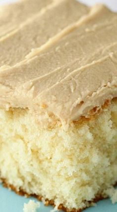 a piece of cake with frosting sitting on top of a blue and white plate