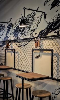 three wooden stools sitting next to each other in front of a wall with graffiti on it