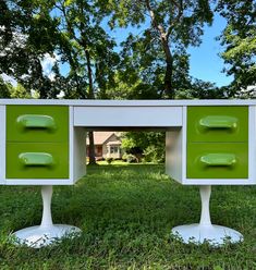 two green and white dressers sitting in the middle of a grass covered park area