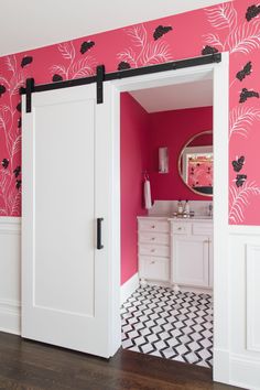 a bathroom with pink walls and white cabinets