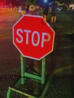 a red stop sign sitting on top of a green chair in the middle of a street