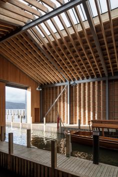 the inside of a boathouse with wooden walls and benches on the water's edge