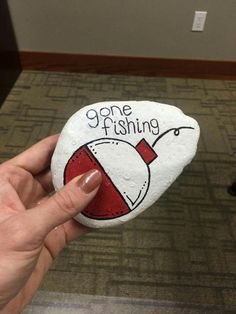 someone is holding a rock that says gone fishing