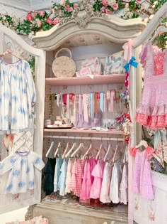 a closet filled with lots of baby clothes and dresses hanging on the wall next to each other