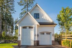 a white house with two garages on the front and one above it's door