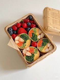 a basket filled with fruits and vegetables next to a wicker box full of strawberries