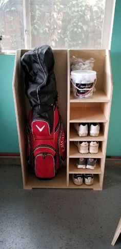 a red bag sitting on top of a wooden shelf next to a pair of shoes