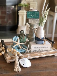 a wooden tray with shells, seashells and other items on top of it