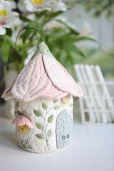 a small white birdhouse sitting on top of a table