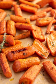 carrots with herbs and seasoning sitting on a cutting board, ready to be cooked