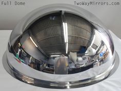 the reflection of an office building in a chrome plated bowl on a white table cloth