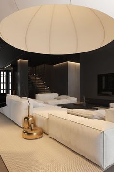 a modern living room with white couches and large round light fixture in the center