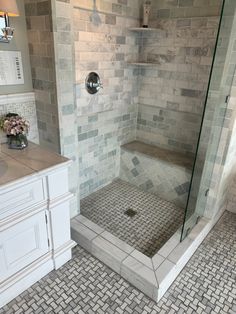 a walk in shower sitting next to a sink and a toilet on top of a tiled floor