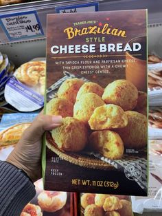 a person holding up a menu for brazilian style cheese bread in front of other food items