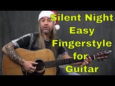 a man in a santa hat playing an acoustic guitar with the words silent night easy fingerstyle for guitar