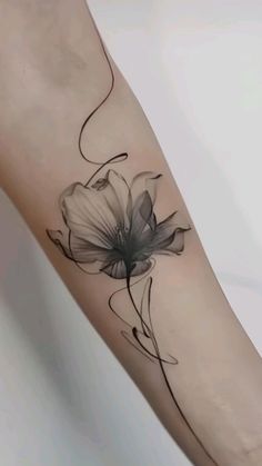 a black and white flower tattoo on the arm