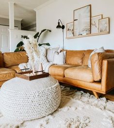 a living room with leather furniture and rugs on the floor, including a large ottoman