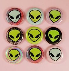 six alien buttons on a pink background