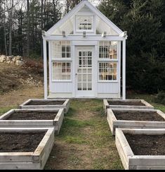 a small white house sitting in the middle of a field