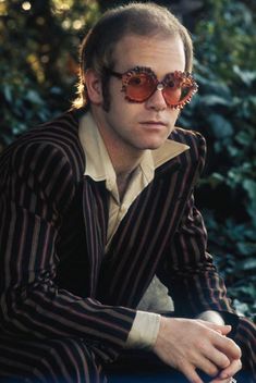 a man wearing sunglasses sitting on a bench