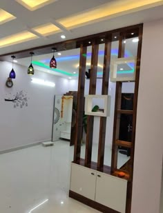 an empty room with white walls and wood trimmings on the ceiling is lit by colorful lights