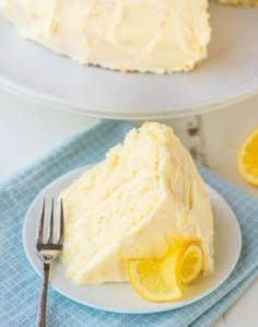 a slice of lemon cake on a white plate with a blue napkin and fork next to it