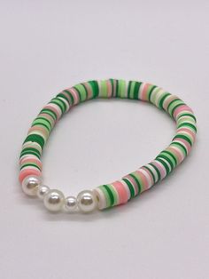 Handmade 7 in. preppy beaded bracelet. Contains green, dark green, pink, and white 6mm clay beads. Also has super cute pearl beads!! This is a super cute green and pink bracelet which is great for easter! It's perfect for a gift for yourself or anyone else!!  I can custom create any jewelry for you. Just let me know what colors you want, and if you want a word on it or not. I can also make phone charms and rings, and necklaces. Aesthetic Green Clay Bead Bracelets, Pink And Green Clay Bead Bracelet, Green Clay Bead Bracelet, Make Clay Beads, Beige Bracelet, Heishi Bracelet, Clay Bead Necklace, Preppy Jewelry, Diy Jewelry Unique