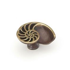 an antique brass door knob with a spiral design on the front and center, set against a white background